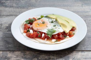 Huevos Rancheros ahşap masada. Geleneksel Meksika kahvaltısı.
