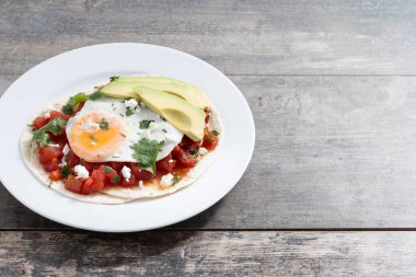 Huevos Rancheros ahşap masada. Uzayı kopyala Geleneksel Meksika kahvaltısı.