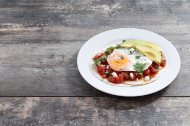 Huevos Rancheros ahşap masada. Uzayı kopyala Geleneksel Meksika kahvaltısı.
