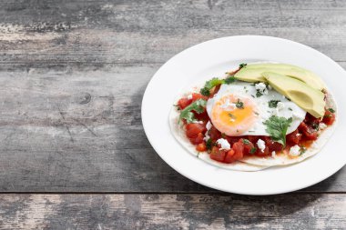 Huevos Rancheros ahşap masada. Uzayı kopyala Geleneksel Meksika kahvaltısı.