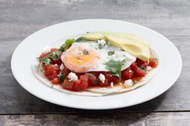 Huevos Rancheros ahşap masada. Geleneksel Meksika kahvaltısı.