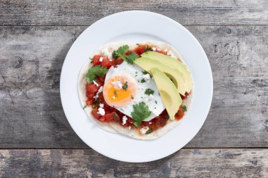 Huevos Rancheros ahşap masada. Geleneksel Meksika kahvaltısı.