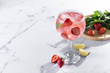 Beyaz mermer arka planda çilekli cin tonik kokteyli. Boşluğu kopyala