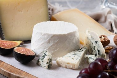 Tahta masada fındıklı, incirli ve üzümlü farklı peynirler.