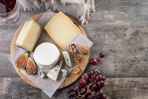 Tahta masada fındıklı, incirli ve üzümlü farklı peynirler.
