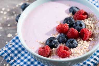 Tahta masada böğürtlenli sağlıklı meyve suyu kasesi.