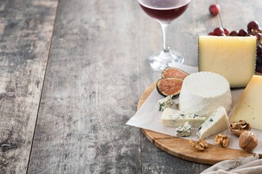 Tahta masada fındıklı, incirli, üzümlü ve şaraplı farklı peynirler. Boşluğu kopyala