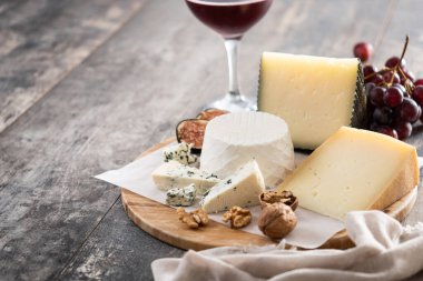 Tahta masada fındıklı, incirli, üzümlü ve şaraplı farklı peynirler. Boşluğu kopyala