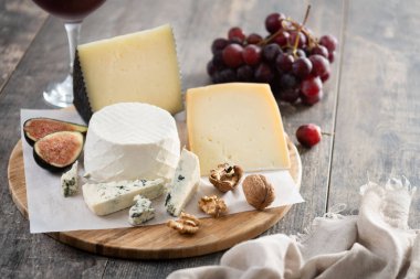 Tahta masada fındıklı, incirli, üzümlü ve şaraplı farklı peynirler. Boşluğu kopyala