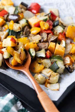 Kızarmış sebzeler, siyah arka planda fırın tepsisinde.. 