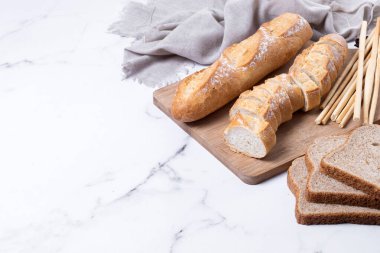 Beyaz mermer arka planda çeşitli ekmek ürünleri. Boşluğu kopyala