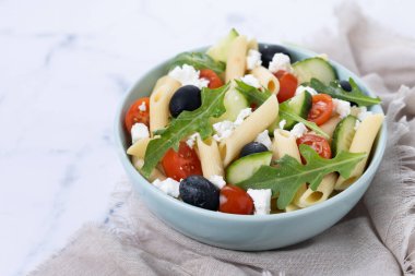 Akdeniz Makarna Salatası kasede Taze sebzeler ve beyaz mermer arka planda bitkiler
