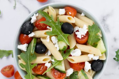 Akdeniz Makarna Salatası kasede Taze sebzeler ve beyaz mermer arka planda bitkiler