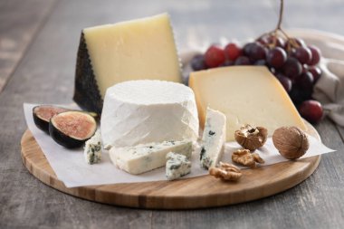 Tahta masada fındıklı, incirli, üzümlü ve şaraplı farklı peynirler.