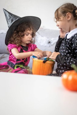 Cadılar Bayramı kostümlü çocuklar evde şeker paylaşıyorlar. Şaka mı şeker mi konsepti.