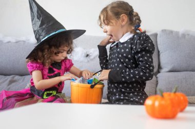 Cadılar Bayramı kostümlü çocuklar evde şeker paylaşıyorlar. Şaka mı şeker mi konsepti.