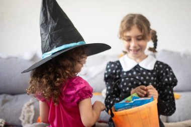 Cadılar Bayramı kostümlü çocuklar evde şeker paylaşıyorlar. Şaka mı şeker mi konsepti.