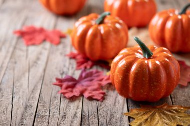 Sonbahar balkabakları sonbahar yapraklı, ahşap arka planda. Boşluğu kopyala