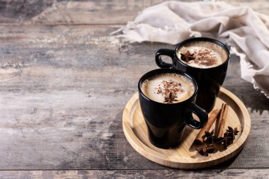 Siyah bardakta Chai Latte, ahşap masada. Boşluğu kopyala