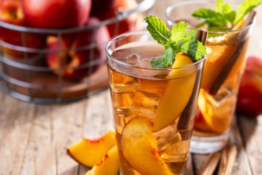 Şeftalili buzlu çayı bardakta, buz küpleriyle ahşap masada tazeliyorum. Boşluğu kopyala