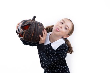 Cadılar Bayramı kostümlü kız elinde balkabağı beyaz arka planda şaşırmış bir ifade var.