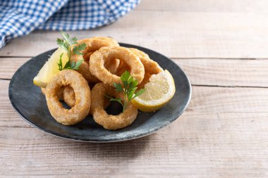 Ahşap masada kızarmış kalamar halkaları. Boşluğu kopyala
