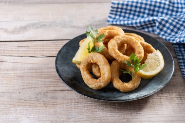 Ahşap masada kızarmış kalamar halkaları. Boşluğu kopyala