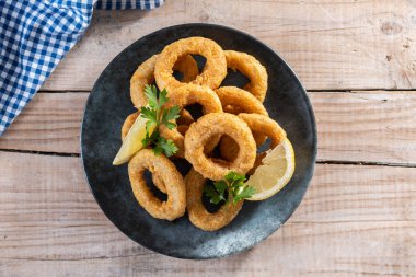 Ahşap masada kızarmış kalamar halkaları.