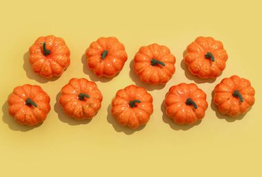 Sarı arkaplanda sonbahar balkabağı deseni. 