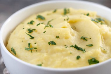 Tahta masadaki beyaz kasede patates püresi. Kapat.