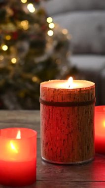 Red Christmas candles with holiday lights and christmas tree background. Copy space