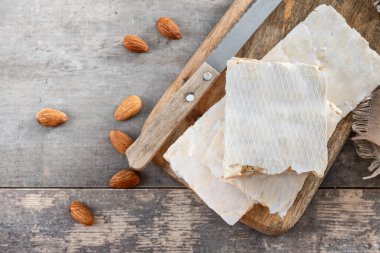 Geleneksel Noel tatlısı, ahşap masadaki lezzetli badem nugat parçaları (turron duro). Üst Manzara. Boşluğu kopyala