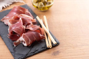 Tahta masada İspanyol Serrano Jambonu dilimleri. Boşluğu kopyala