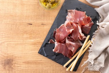 Tahta masada İspanyol Serrano Jambonu dilimleri. Üst Manzara. Boşluğu kopyala