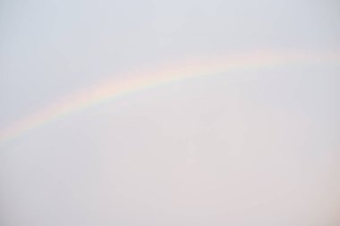 Yağmurdan sonra parlak gökyüzüne odaklanamadım. Arka planda bir gökkuşağı Odaklanamayan gökyüzünün arka planı.