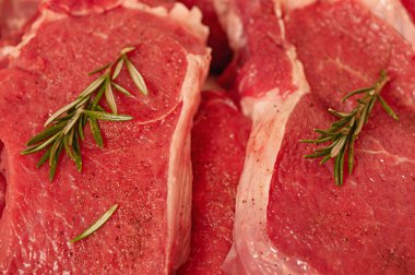 Beef steaks with rosemary close-up. Fresh meat.