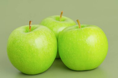 Üç yeşil elma. Yeşil arka planda elma meyvesi