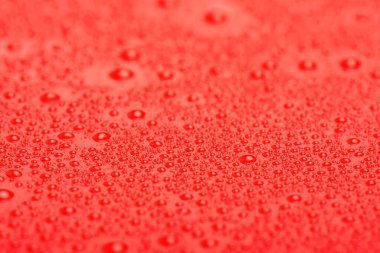 Damlalı soyut kırmızı arkaplan. Su damlalı kırmızı plastik makro fotoğraf