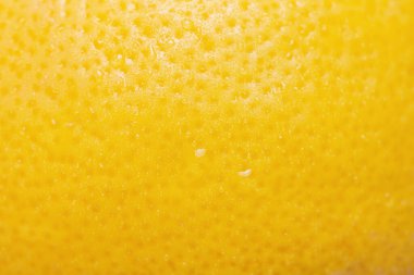 Arka planda su damlaları olan bir limon. Limon rengi sarı, ince odak noktası.