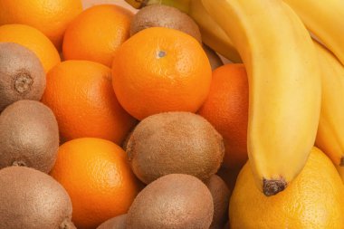 Arka plan olarak tropikal meyveler. Kivi, portakal, limon ve muz meyveleri