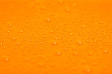 Turuncu plastiğin üzerine su damlası dokusu