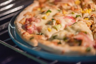 Servis için seramik tabakta pizza. Tavuk ve pastırmalı pizza.