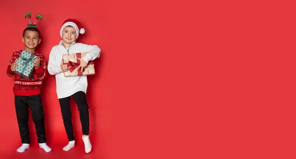 Sevimli Arkadaş Stüdyoda Kırmızı Arka Planda Noel Hediyeleriyle Eğleniyor — Stok fotoğraf