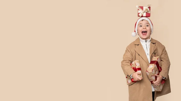 Забавный Маленький Мальчик Рождественскими Подарками Шокированным Лицом Светло Коричневом Фоне — стоковое фото