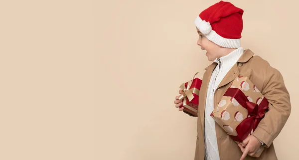 Αστείο Αγοράκι Χριστουγεννιάτικα Δώρα Και Σοκαρισμένο Πρόσωπο Ανοιχτό Καφέ Φόντο — Φωτογραφία Αρχείου