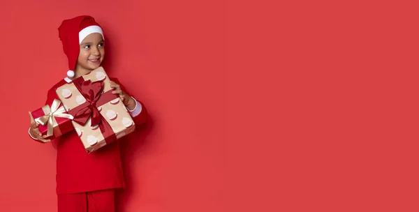 Χαριτωμένο Αγοράκι Στην Πιτζάμα Των Χριστουγέννων Δώρα Κόκκινο Φόντο — Φωτογραφία Αρχείου