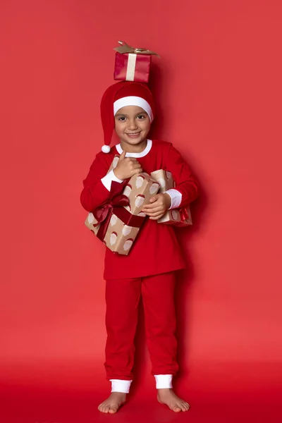 Bonito Menino Pijama Natal Com Presentes Fundo Vermelho — Fotografia de Stock