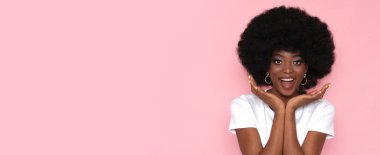 Mutlu Afro-Amerikalı kadın pembe arka planda mesaj yeri var..