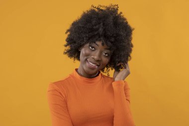 Sarı arka planda mutlu siyah kadın.