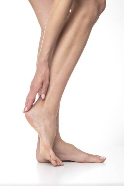 İzole edilmiş beyaz arka planda ince kadın bacakları.